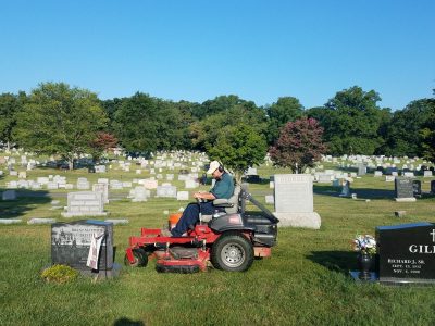 a man drives a riding mower while noise dosimetry testing is conducted.